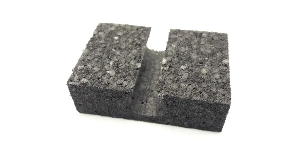 Schwarzes, kompaktes Produkt von Remeha mit einer Aussparung in der Mitte. Die Oberfläche ist körnig strukturiert.